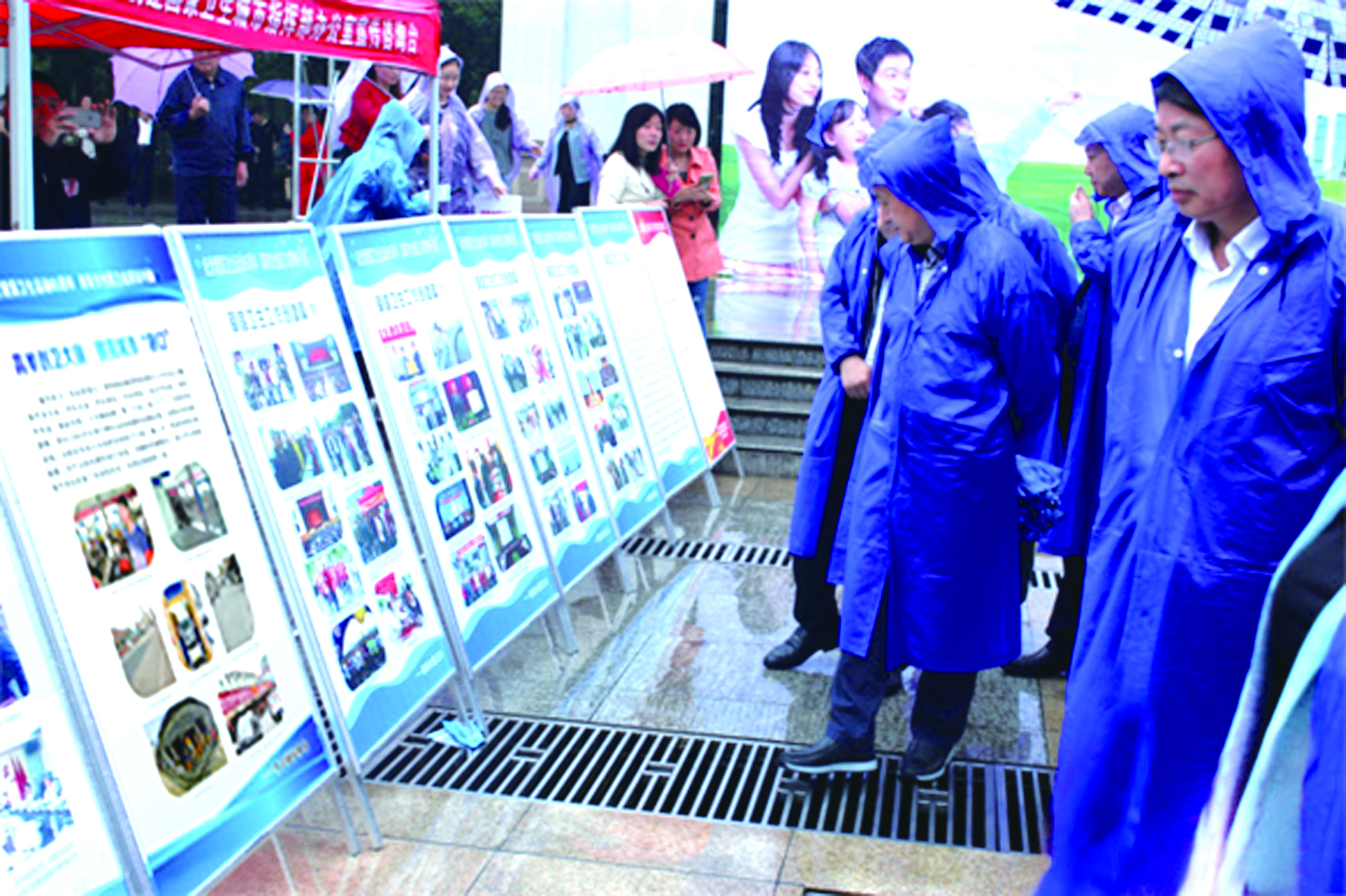 圖為市民冒雨在觀(guān)看我司圖文并茂創(chuàng)衛(wèi)成果展板。